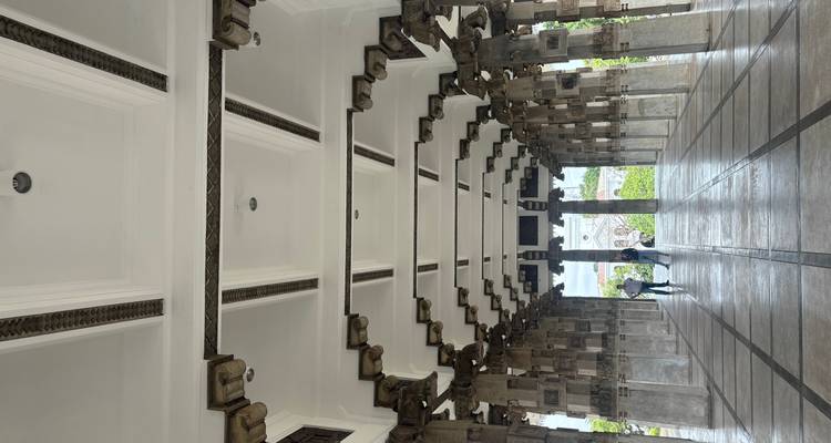 Interior of a large corridor with pillars and people walking.