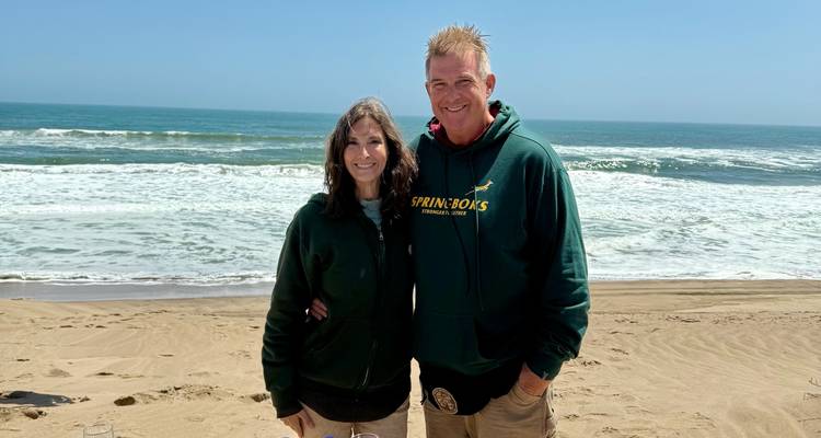 Deux personnes sur une plage avec l'océan en arrière-plan.