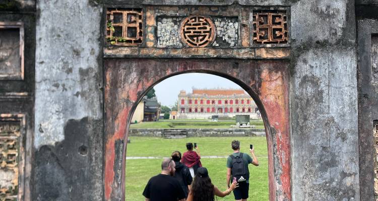 Des gens marchant sous des arches de pierre ornées dans un site historique