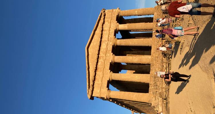 Des touristes explorant un temple classique avec des colonnes.