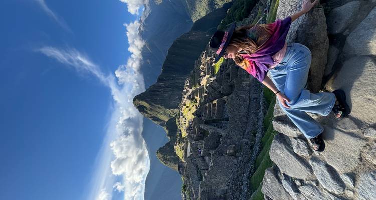 Personne assise avec les ruines du Machu Picchu en arrière-plan.