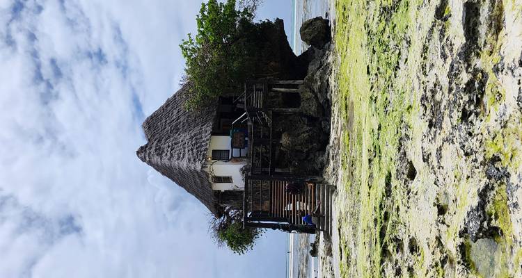Restaurant unique situé sur un rocher entouré d'eau à marée basse.