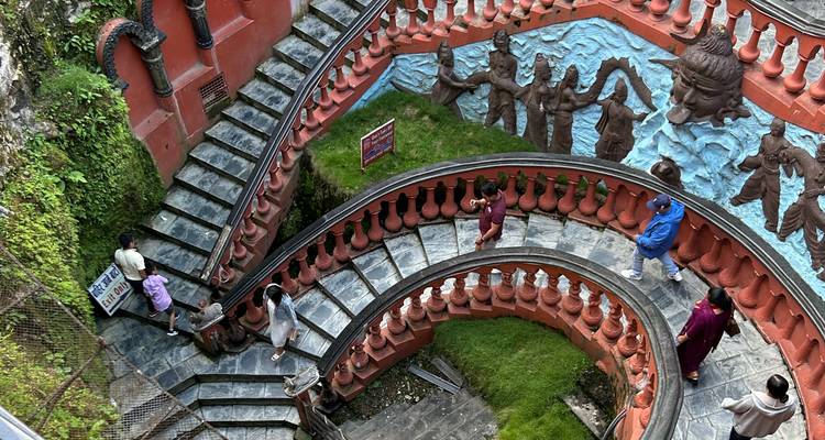 Un escalier en colimaçon avec des sculptures artistiques sur les murs.