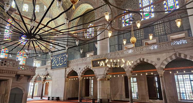 Interior of an ornate mosque with stained glass.