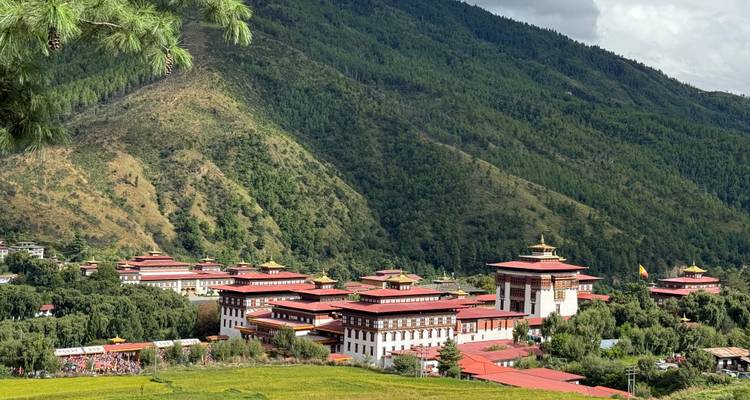 Vue panoramique de l'architecture bhoutanaise au milieu de collines verdoyantes luxuriantes.