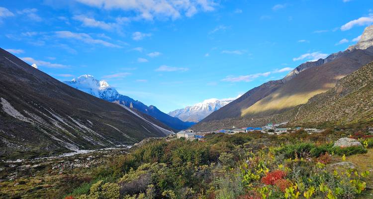 Vallée entourée par les montagnes himalayennes, parsemée de petites maisons.