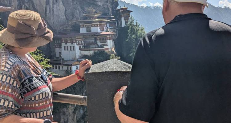 People looking at the Paro Taktsang monastery on a cliff.
