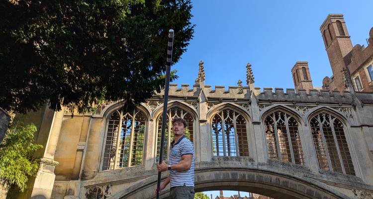 Guide touristique menant un visiteur près d'un pont historique voûté.