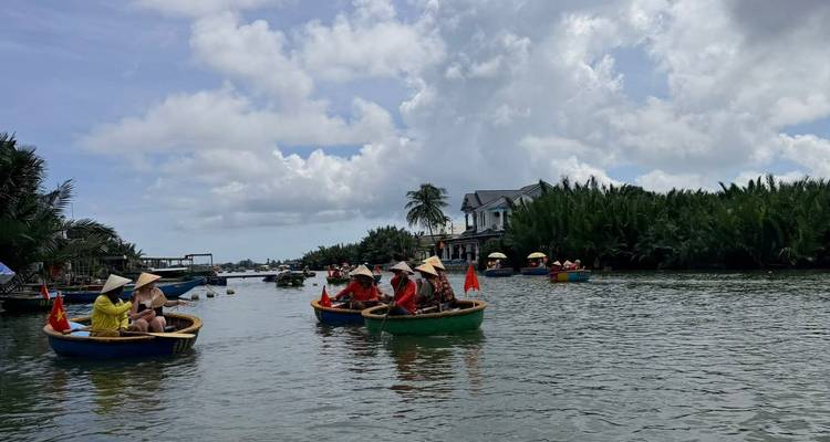 Des gens ramant dans des bateaux sur une rivière avec un environnement luxuriant.