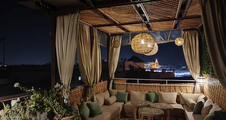 Terrasse extérieure confortable avec vue sur les lumières de la ville.