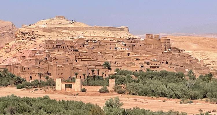 Ancienne cité sur une colline avec de la verdure environnante.