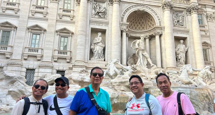 Groep mannen poserend voor de Trevi Fontein.