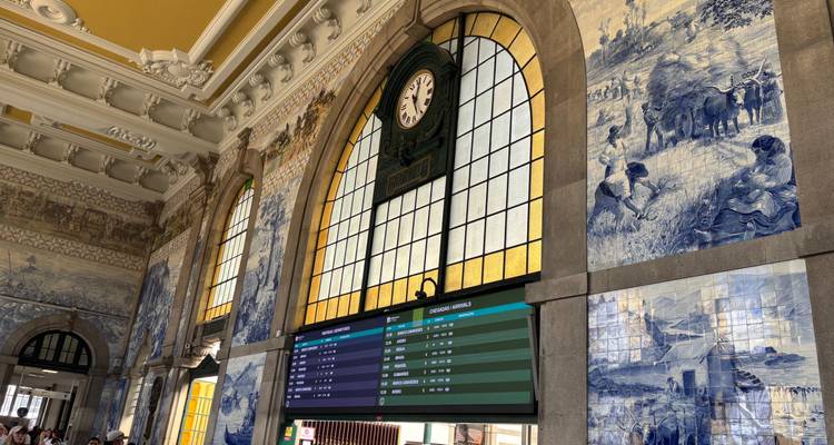 Interior of a train station with traditional blue-and-white tiles and a clock.