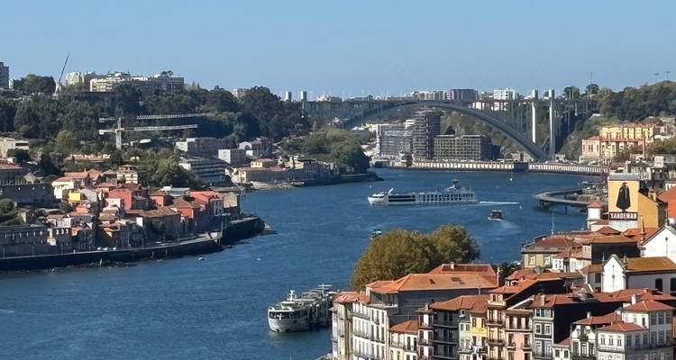 Aerial view of Porto with the Douro River and a prominent bridge.