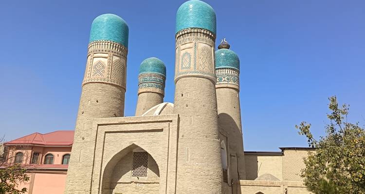 Historic building with turquoise domes under a clear blue sky.