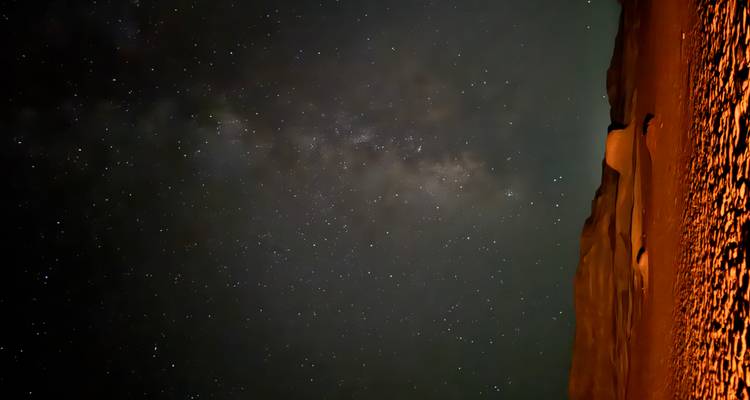 Ciel nocturne étoilé au-dessus des dunes du désert.