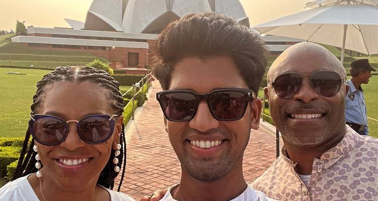Group of people posing in front of a modern lotus-shaped building.
