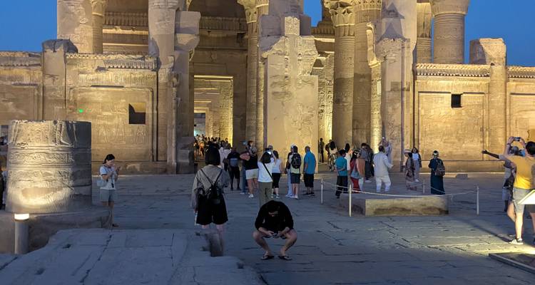 Tourists exploring an ancient Egyptian temple during dusk.