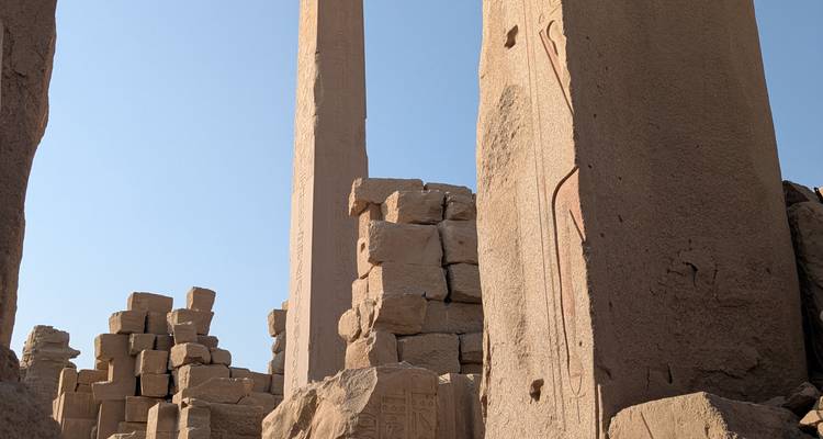Ancient ruins with towering columns under a clear sky.
