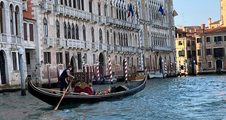 Góndola navegando por un canal con edificios históricos.