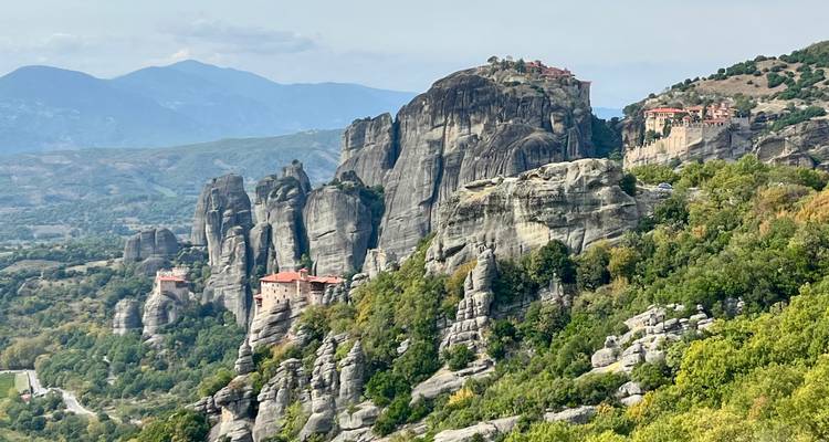Monastères rupestres perchés sur des falaises dans une région montagneuse.