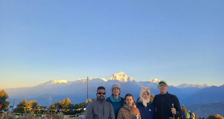 Un groupe de personnes avec une toile de fond de montagne au lever du soleil.