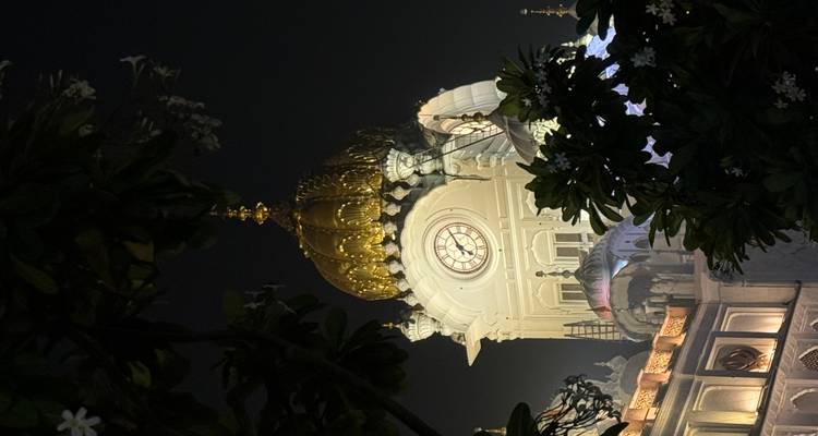 Clock tower with a golden dome at night.