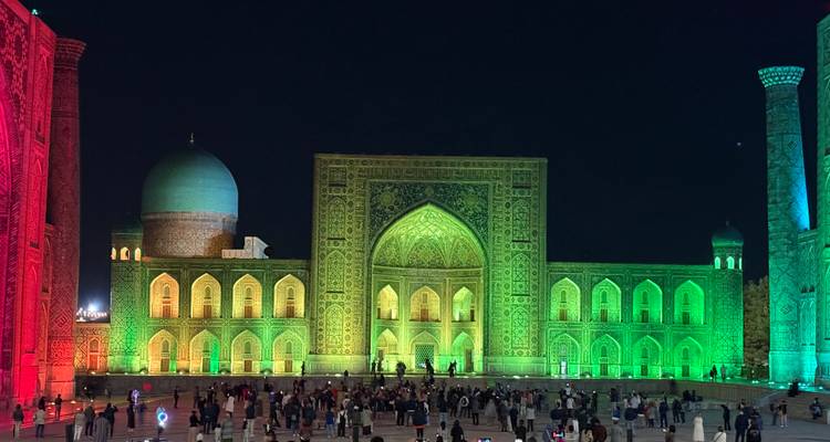 Registan illuminé la nuit avec des visiteurs.