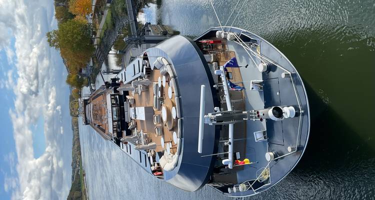 Vue aérienne d'une rivière avec un grand bateau amarré à une jetée.