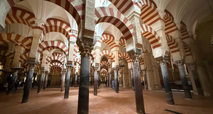 Interior de la Mezquita-Catedral con arcos distintivos rojos y blancos.