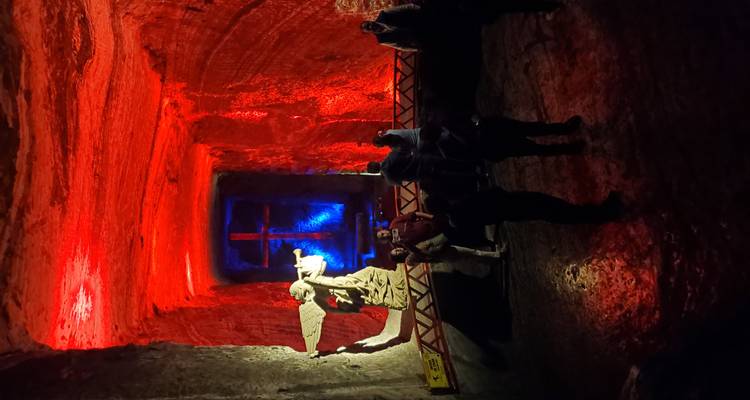 Ondergrondse kathedraal met kleurrijke verlichting en beelden.