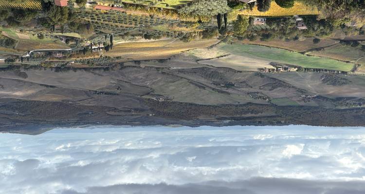 Vista panorámica de un paisaje rural montañoso con viñedos.