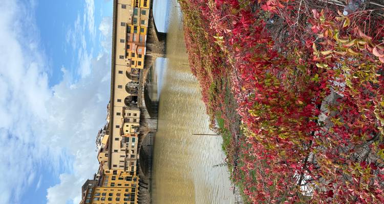 El puente Ponte Vecchio sobre el río Arno con tiendas coloridas.