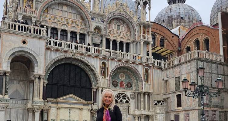 Vrouw poseert voor een grote basiliek met koepels.