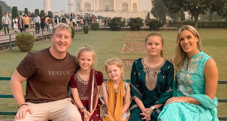 Famille assise avec le Taj Mahal en arrière-plan.