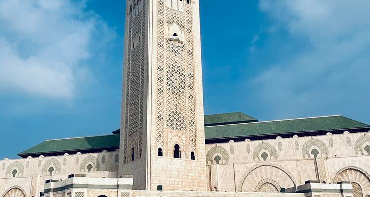 Hassan II Mosque minaret in Casablanca, Morocco against a blue sky.