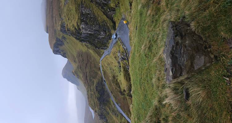 Scenic view of winding road through mountains in cloudy weather.