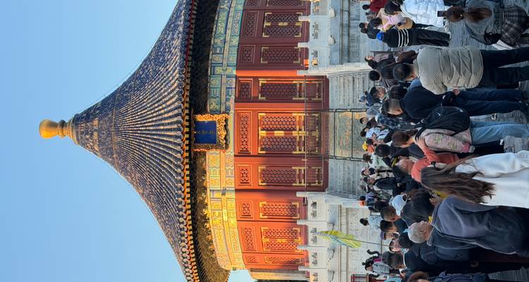 Une zone de temple animée avec des touristes observant une structure traditionnelle.
