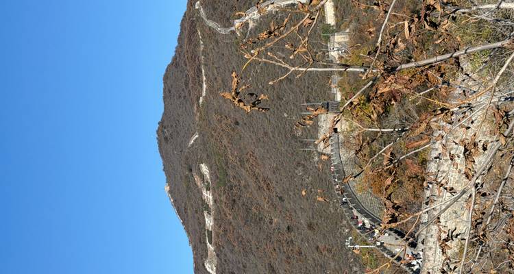 Vue de la Grande Muraille de Chine serpentant à travers des collines escarpées.