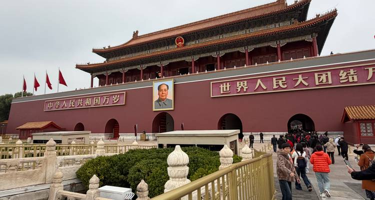 Une grande entrée avec des bannières rouges politiques et un portrait de Mao Zedong.
