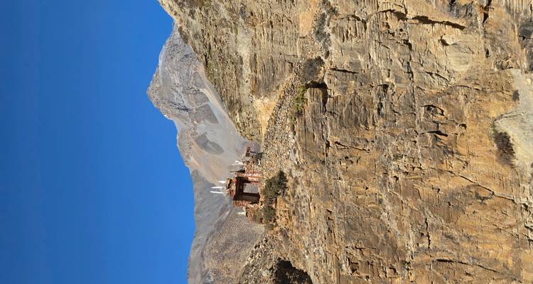 Small shrine on a rocky cliff against a blue sky.
