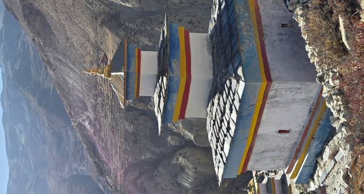 Stupa bouddhiste surplombant un paysage montagneux.