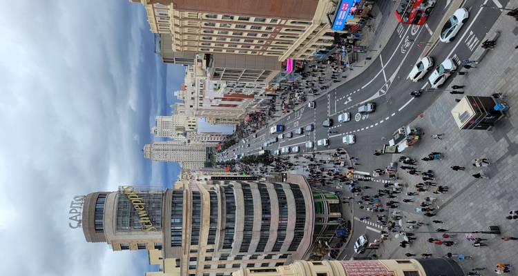 Drukke stadsstraat met iconisch gebouw.