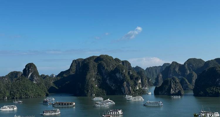Baie d'Halong avec bateaux et formations karstiques.