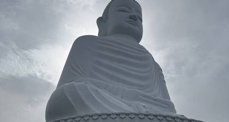 Statue de Bouddha blanc contre un ciel nuageux.
