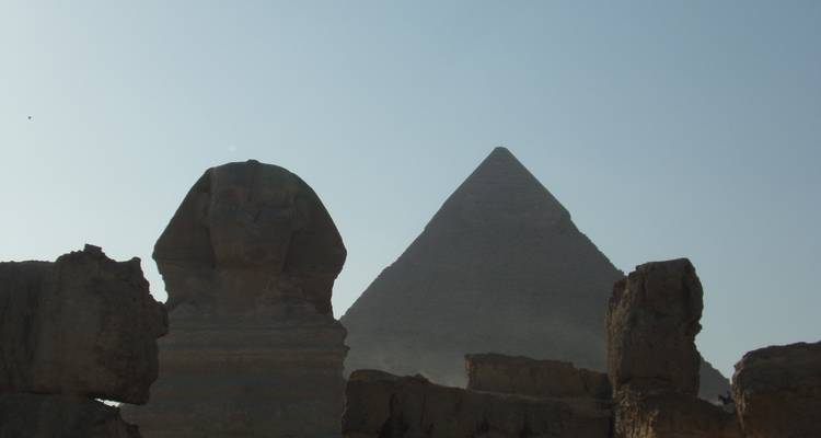 Die Große Sphinx und Pyramide von Gizeh als Silhouette gegen den Himmel.