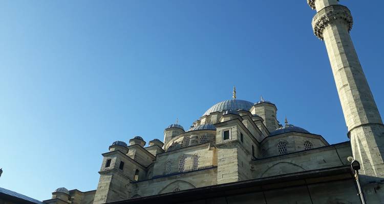 Moskee met talloze koepels en een blauwe lucht op de achtergrond.