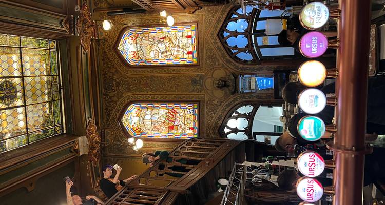 Intérieur d'un pub avec des vitraux et un bar.