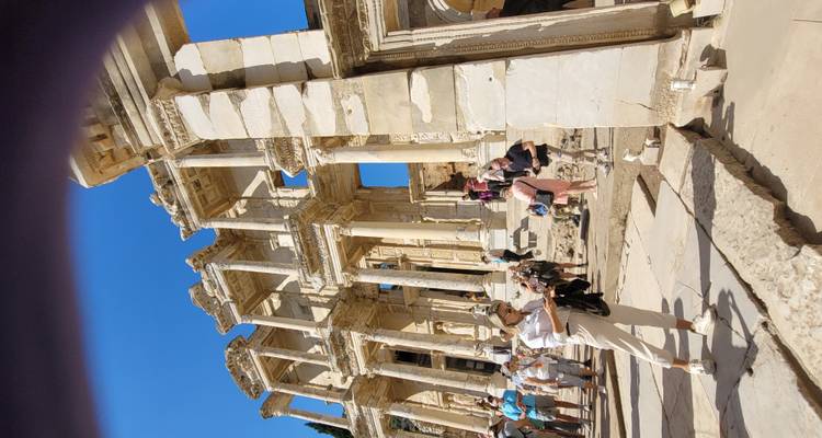 Toeristen die oude ruïnes met hoge zuilen verkennen.