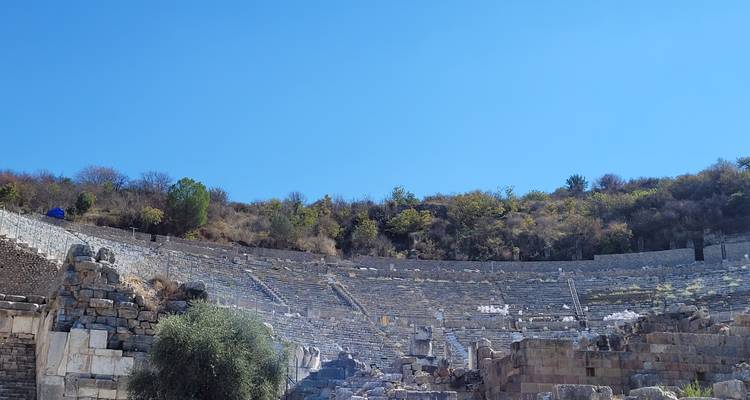 Oude amfitheater ruïnes met toeristen eromheen.